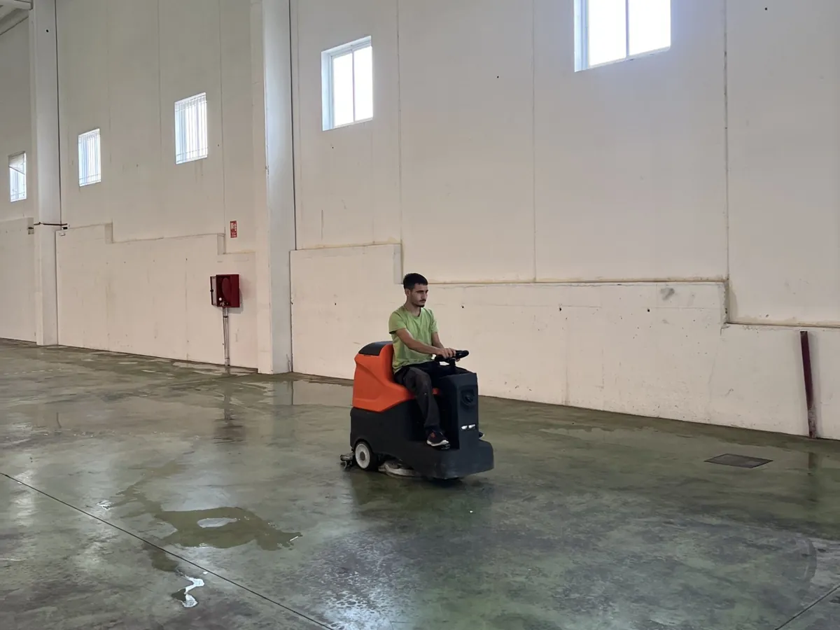 Operario de Barrachina con la fregadora industrial en una nave vacía